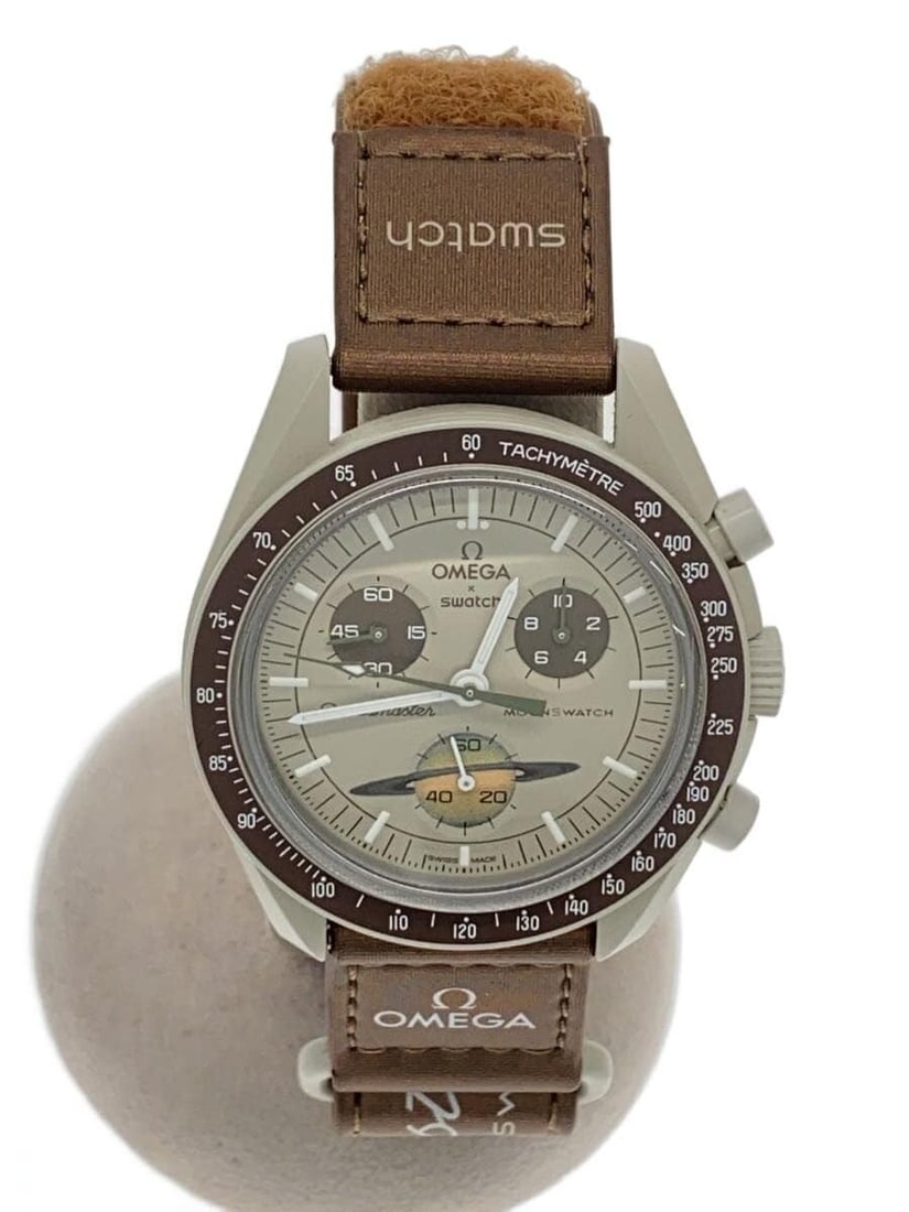 OMEGAxSWATCH Mission to Saturn Beige Wristwatch: OMEGAxSWATCH Mission to Saturn Beige Wristwatch This OMEGAxSWATCH Mission to Saturn men's wristwatch features a beige color scheme and is crafted in Switzerland. The watch is pre-owned and shows sligh