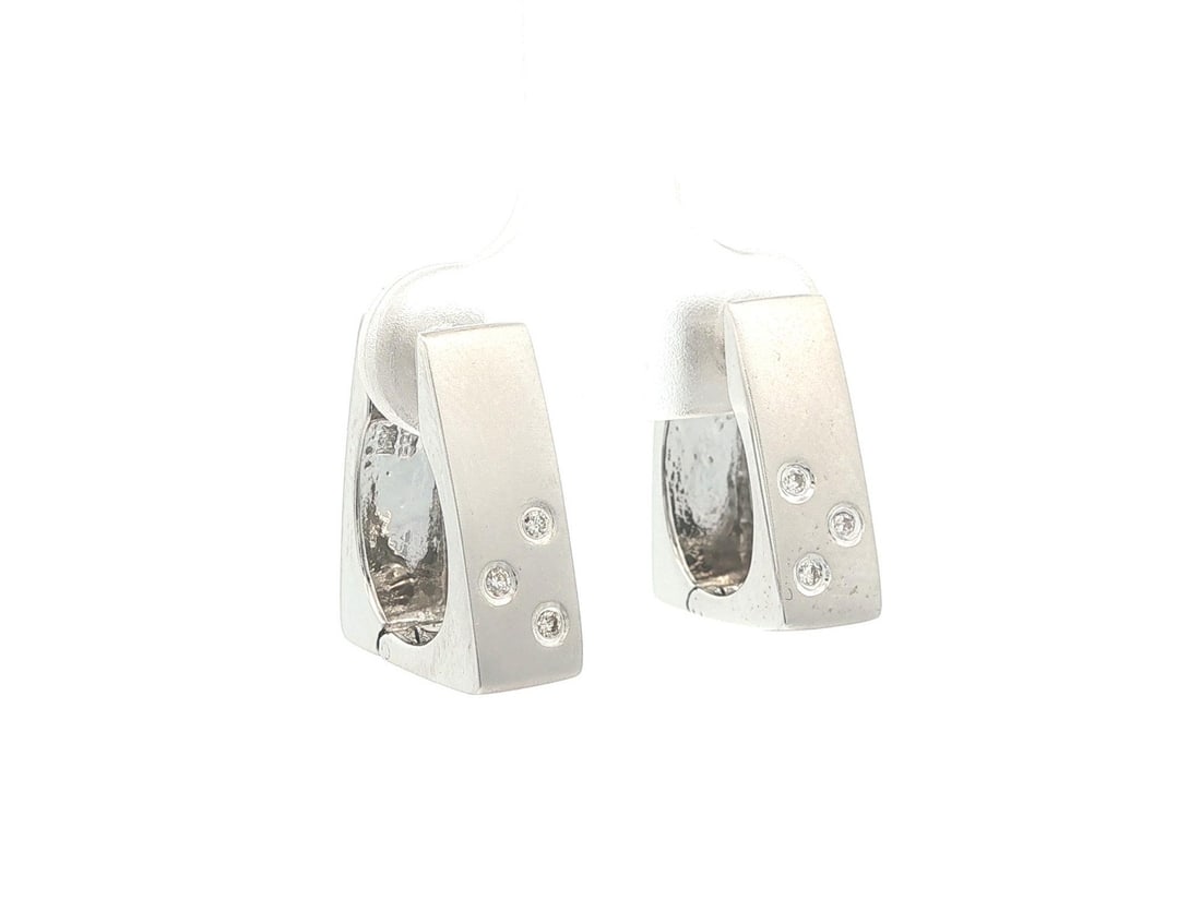 Geometric Flat Huggie Hoops in 14k White Gold with Diamonds Matte Finish: Geometric Flat Huggie Hoops in 14k White Gold with Diamonds Matte Finish These geometric flat huggie hoop earrings are crafted from solid 14k white gold and feature a matte finish. Each earring is ado