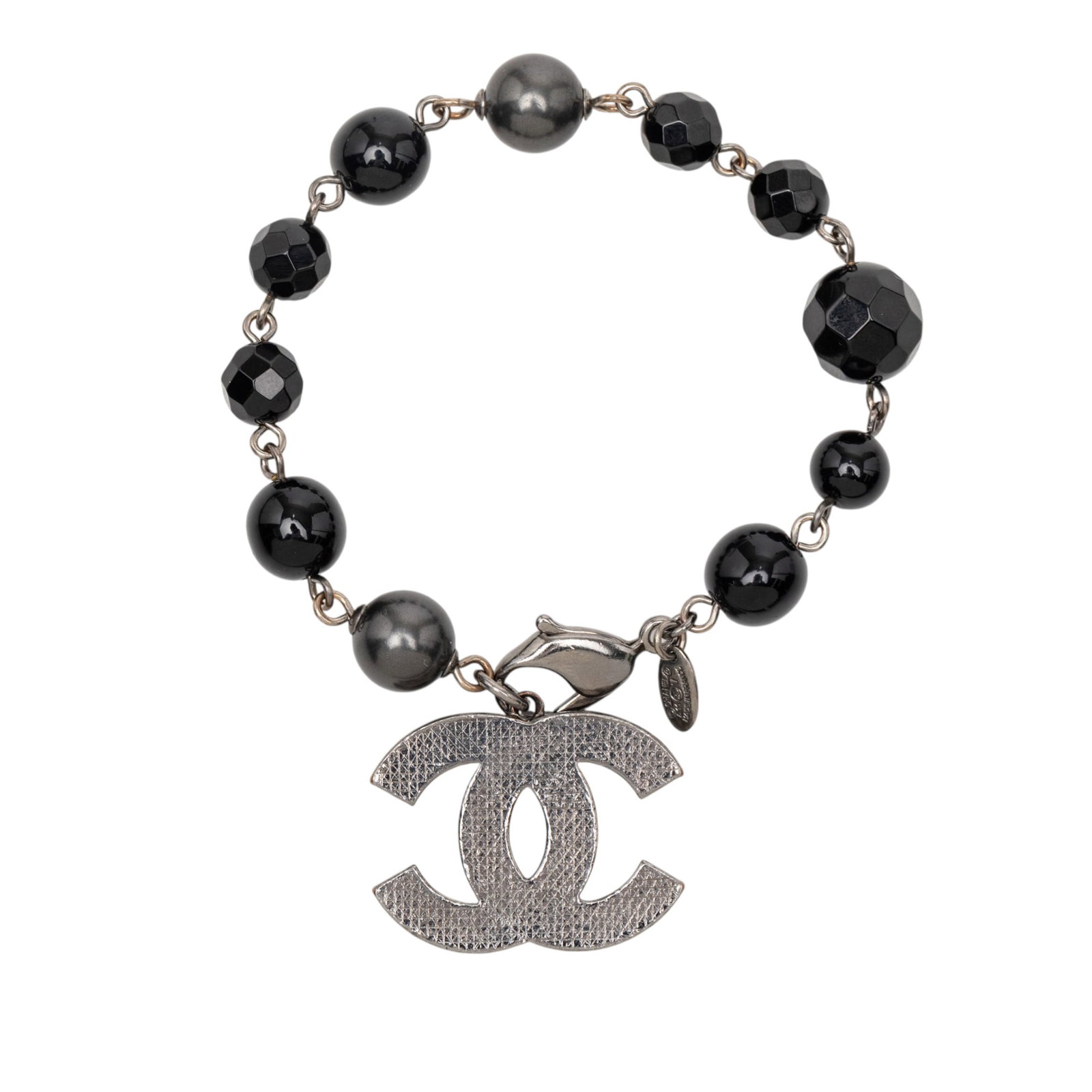 Chanel CC Logo Bracelet with Silver Plating and Faux Pearl Accents: Chanel CC Logo Bracelet with Silver Plating and Faux Pearl Accents This Chanel bracelet features a silver-plated metal construction adorned with faux pearl embellishments, a beaded chain, the signatur