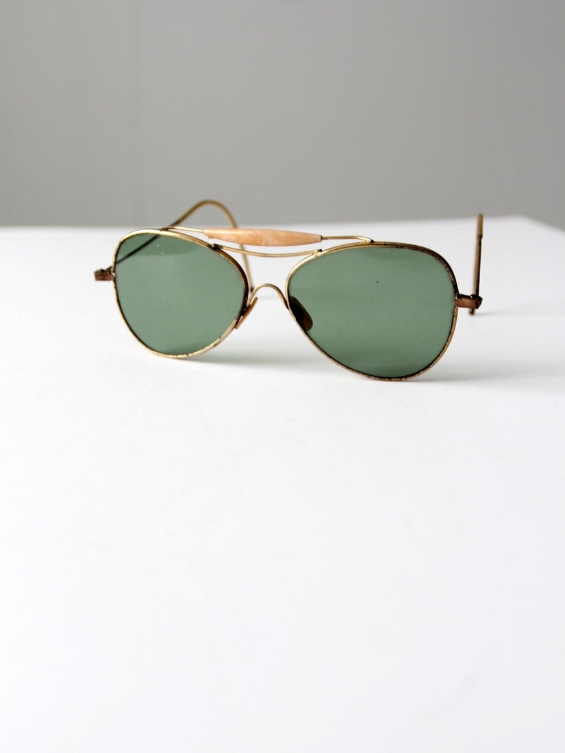 1980s Style Gold Tone Aviator Sunglasses with Marbled Peach Top Bar: 1980s Style Gold Tone Aviator Sunglasses with Marbled Peach Top Bar This rare pair of vintage aviator sunglasses features a slender gold-tone metal frame paired with green-tinted lenses, capturing a t