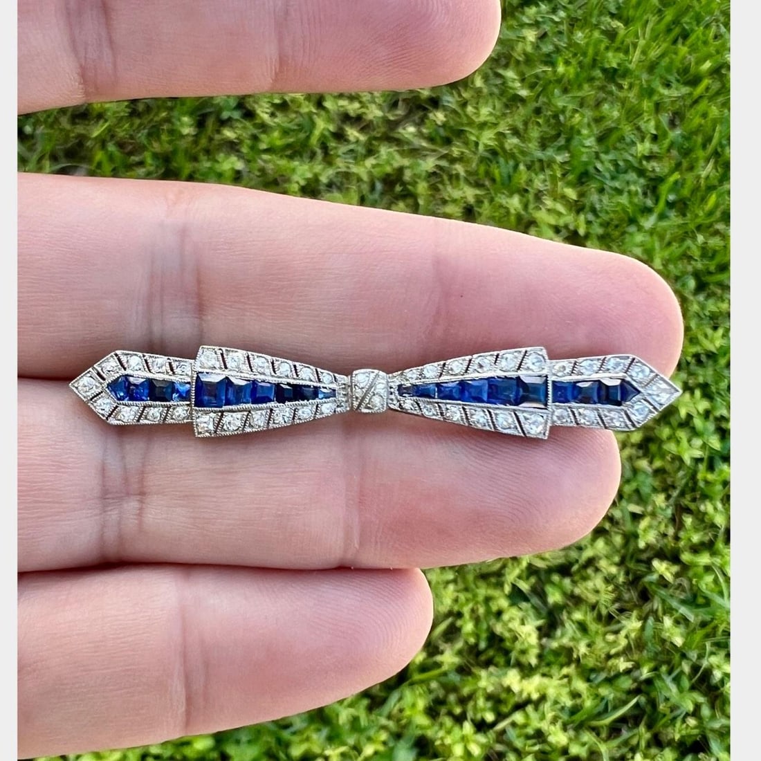 Art Deco Platinum Brooch with Burma Sapphire and Diamond: Art Deco Platinum Brooch with Burma Sapphire and Diamond This exquisite Art Deco brooch is crafted in platinum and features a stunning combination of Burma sapphires and European-cut diamonds. It show