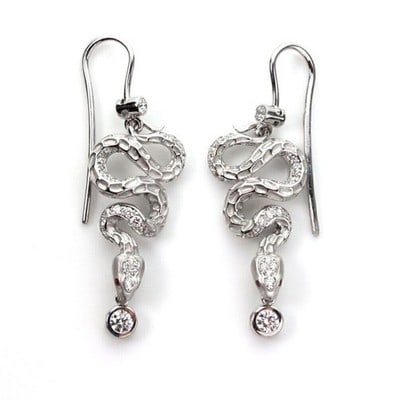 Magerit 18k White Gold Snake Dangle Earrings with Diamonds and Red Sapphires: Magerit 18k White Gold Snake Dangle Earrings with Diamonds and Red Sapphires These Magerit coiled snake dangle earrings are crafted from 18k white gold and feature a sculptural serpent motif. The earr
