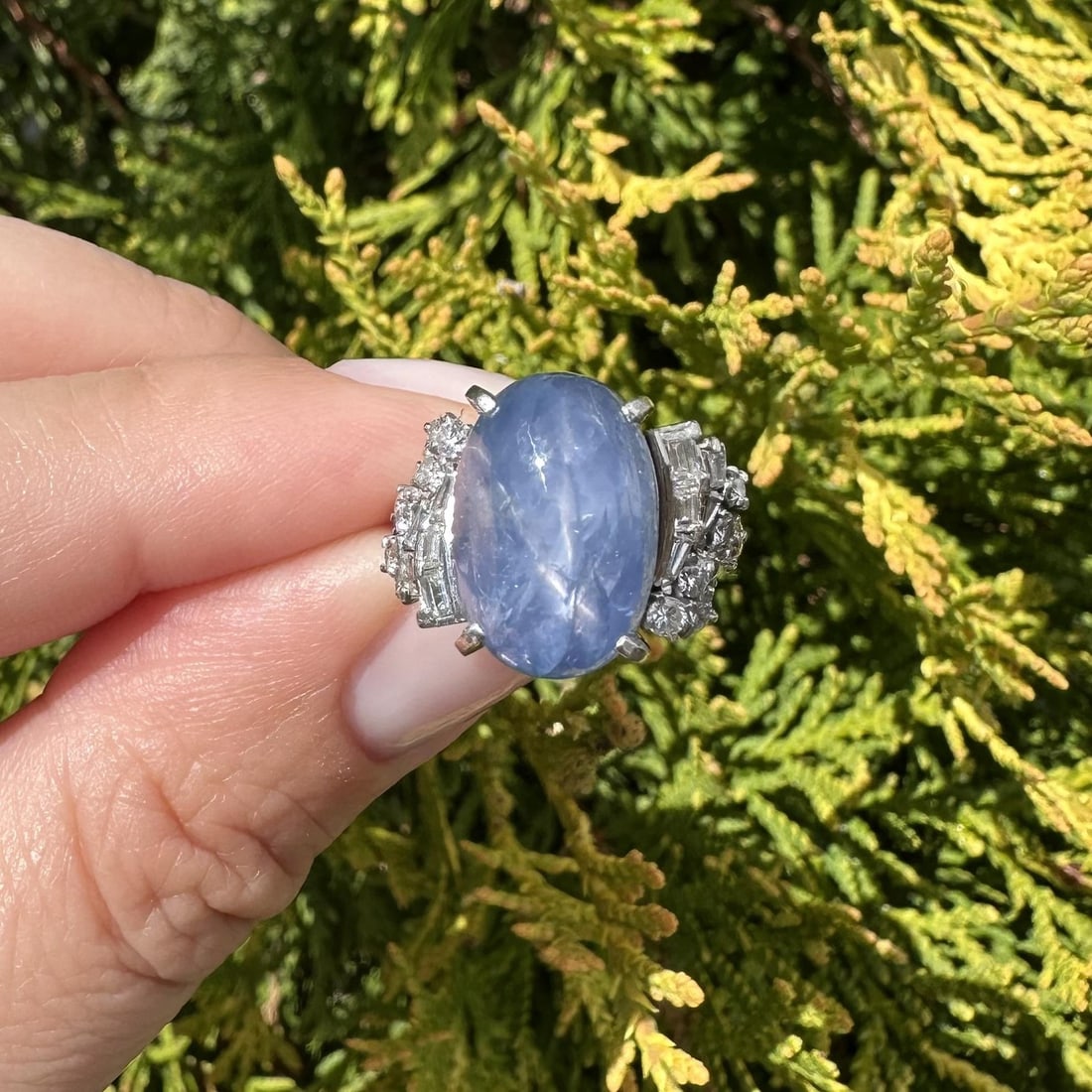 Platinum Ring with Blue Star Sapphire and Diamond Accents Vintage Cocktail Style: Platinum Ring with Blue Star Sapphire and Diamond Accents Vintage Cocktail Style This vintage platinum cocktail ring features a striking 12.39 carat natural blue star sapphire in an oval cabochon cut,