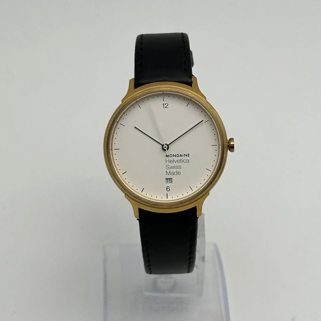 Mondaine Helvetica No1 38mm Gold-Tone Quartz Analog Watch with Black Leather Band: Mondaine Helvetica No1 38mm Gold-Tone Quartz Analog Watch with Black Leather Band The Mondaine Helvetica No1 is a stunning wristwatch that combines classic elegance with modern functionality. Featurin