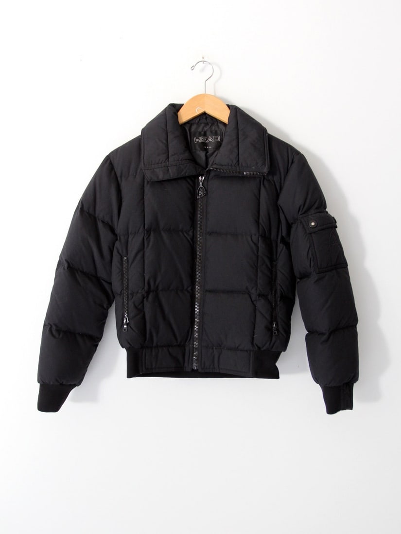 Vintage Head Black Goose Down Ski Jacket with Quilted Design: Vintage Head Black Goose Down Ski Jacket with Quilted Design Embrace vintage style with this classic Head ski jacket, designed for both warmth and fashion. This black puffer coat features a stylish qu