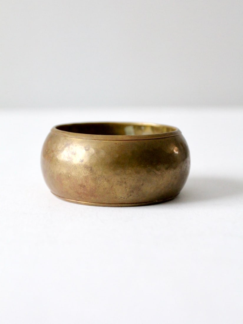 Vintage Chunky Hammered Brass Bangle with Stunning Patina: Vintage Chunky Hammered Brass Bangle with Stunning Patina This vintage chunky hammered brass bangle features a stunning patina that enhances its wide design, making it an exceptional statement piece. 