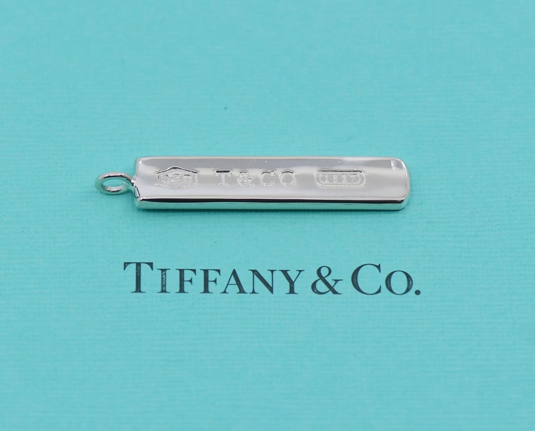 Tiffany & Co Sterling Silver Pendant 43x8mm 100% Authentic: Tiffany & Co Sterling Silver Pendant 43x8mm 100% Authentic This exquisite Tiffany & Co. pendant is crafted from high-quality sterling silver, ensuring both durability and elegance. With a sleek and st
