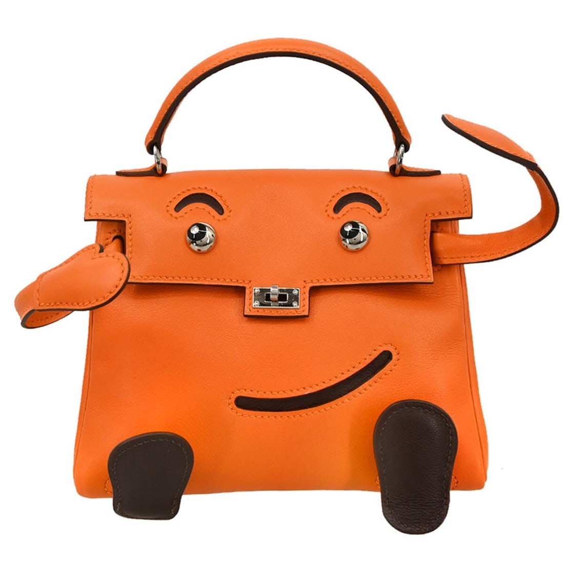 Hermes Kelly Doll orange leather top handle bag: Hermes Kelly Doll orange leather top handle bag This Hermes Kelly Doll Mascot handbag features a distinctive orange leather exterior and a compact, playful design. Crafted in France, it includes a top