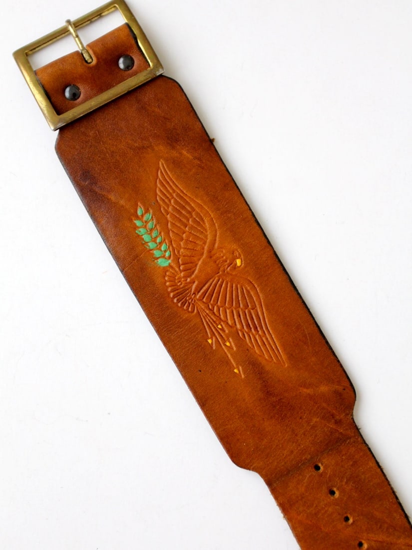 Vintage Eagle Tooled Leather Cuff with Brass Buckle: Vintage Eagle Tooled Leather Cuff with Brass Buckle This Vintage Eagle Leather Cuff showcases a striking design featuring an American eagle gripping an olive branch and arrows, beautifully tooled into