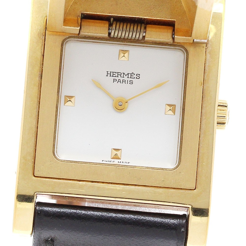 Hermes Medor quartz leather strap ladies wristwatch: Hermes Medor quartz leather strap ladies wristwatch This pre-owned HERMES Medor Quartz women's wristwatch features a stainless steel and gold-plated case paired with a leather bracelet. The white dial