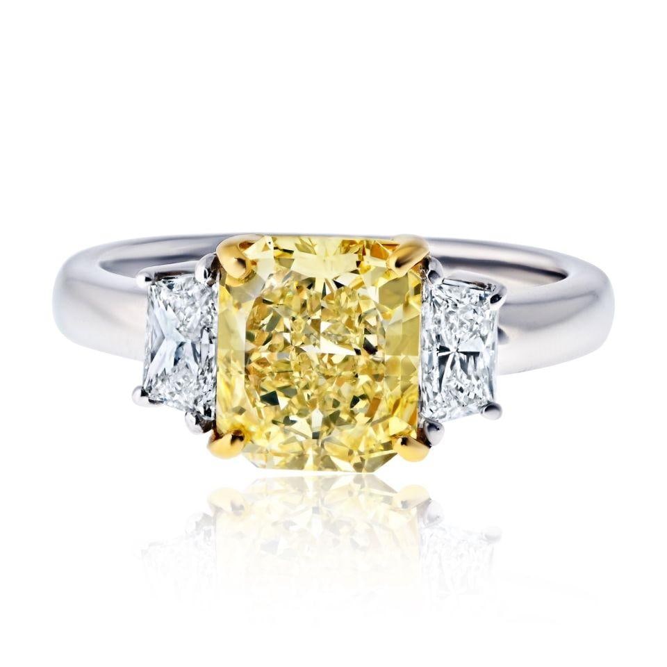 Fancy Yellow Radiant Cut Diamond Ring Platinum 18K Yellow Gold 1.91 Cts: Fancy Yellow Radiant Cut Diamond Ring Platinum 18K Yellow Gold 1.91 Cts This elegant engagement ring features a 1.91 carat fancy yellow radiant cut diamond as the centerpiece, flanked by trapezoid-cut