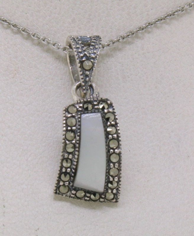 Curved Marcasite Sterling Silver Pendant with Mother of Pearl and Chain: Curved Marcasite Sterling Silver Pendant with Mother of Pearl and Chain This exquisite pendant features a beautiful curved design crafted from .925 sterling silver, highlighted by a custom cut mother 