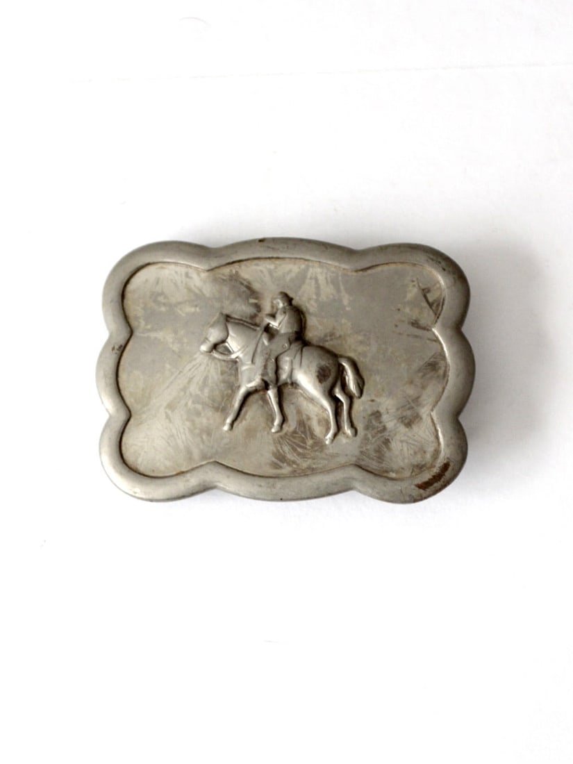 Vintage Silver Tone Western Belt Buckle Cowboy Design 3.25": Vintage Silver Tone Western Belt Buckle Cowboy Design 3.25" This vintage Western belt buckle showcases a striking raised design of a cowboy riding a horse, which adds depth and character to the piece.