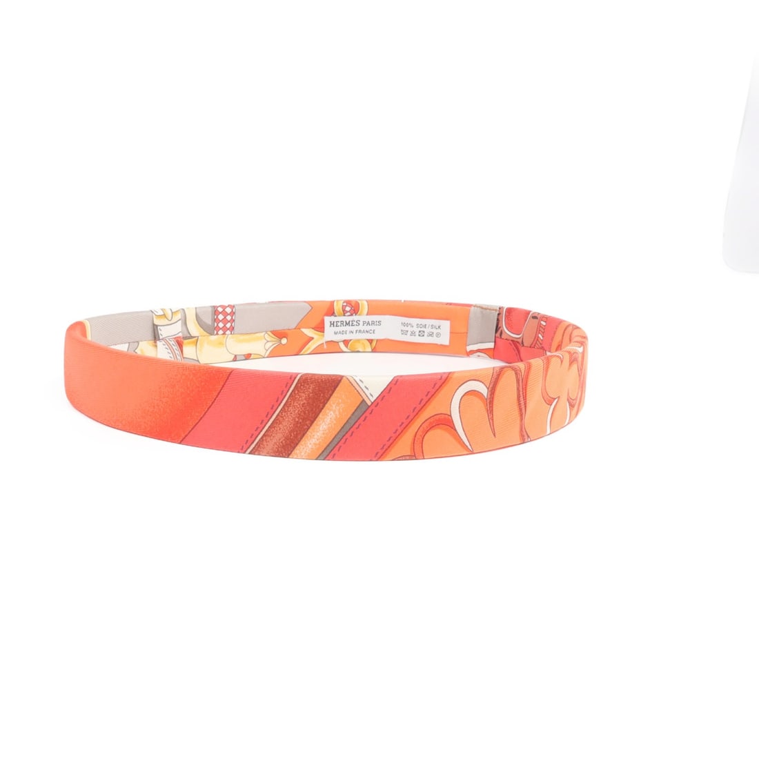 Silk Hair Accessory in Red and Orange by Hermes: Silk Hair Accessory in Red and Orange by Hermes This Hermes hair band is crafted from luxurious silk in a striking red and orange color combination. Made in France, this accessory offers an elegant ad