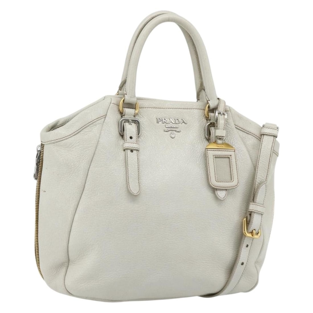 Prada white leather 2way handbag with strap and name tag: Prada white leather 2way handbag with strap and name tag This PRADA 2-way handbag is crafted from leather and features a sophisticated white, gold, and silver color combination. Designed for versatili