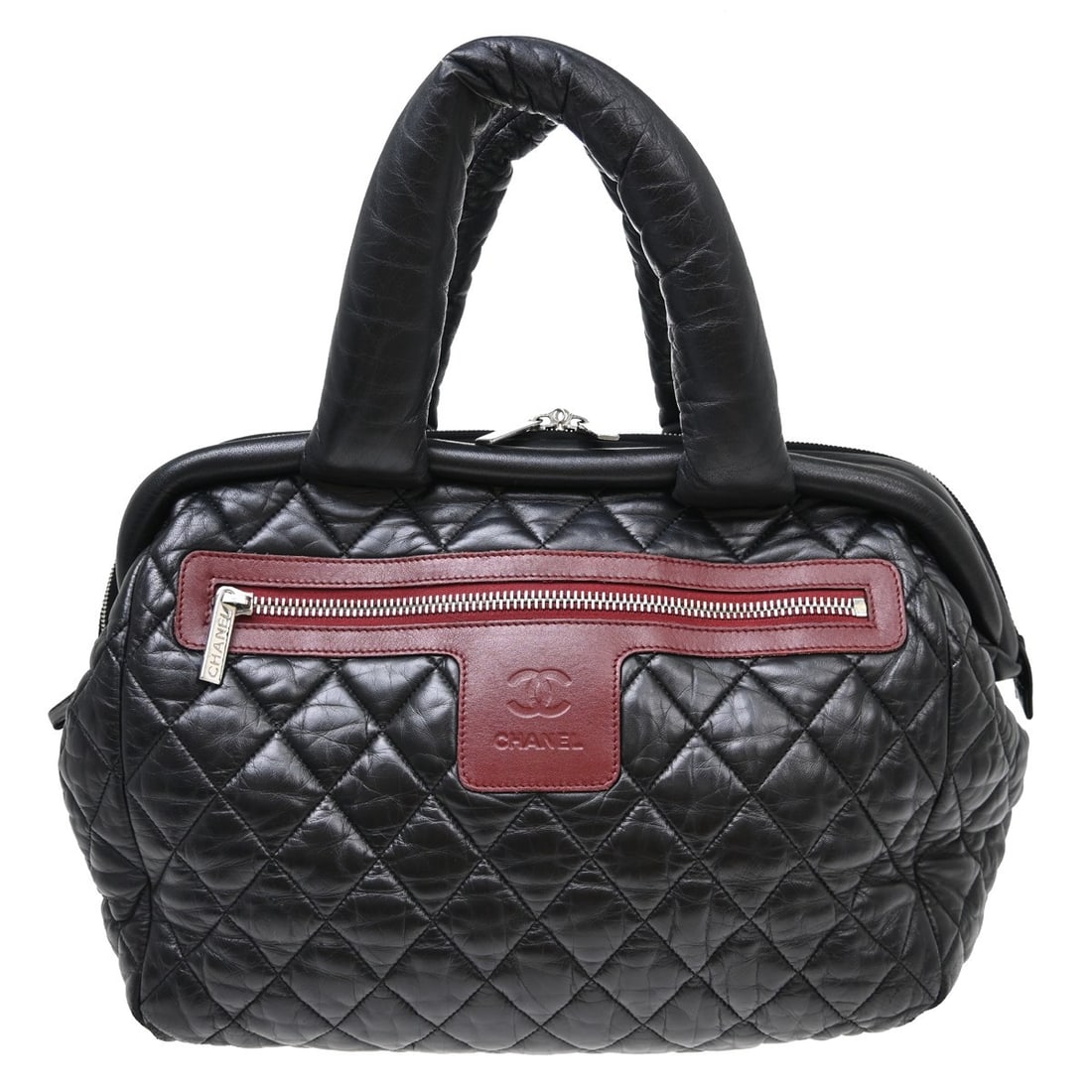CHANEL Coco Cocoon Black Nylon Top Handle Bag: CHANEL Coco Cocoon Black Nylon Top Handle Bag This Chanel Coco Cocoon Bowling Bag is crafted from black leather and nylon, offering a stylish and practical option for everyday use. Designed with a lar