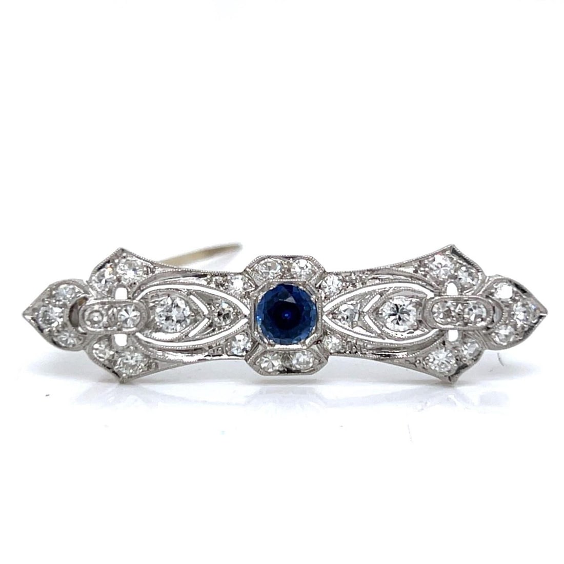 Platinum Art Deco Brooch with Sapphire and Thirty Diamonds: Platinum Art Deco Brooch with Sapphire and Thirty Diamonds This Art Deco brooch is crafted in platinum and features a central sapphire of approximately 0.40 ct, surrounded by 30 diamonds totaling appr