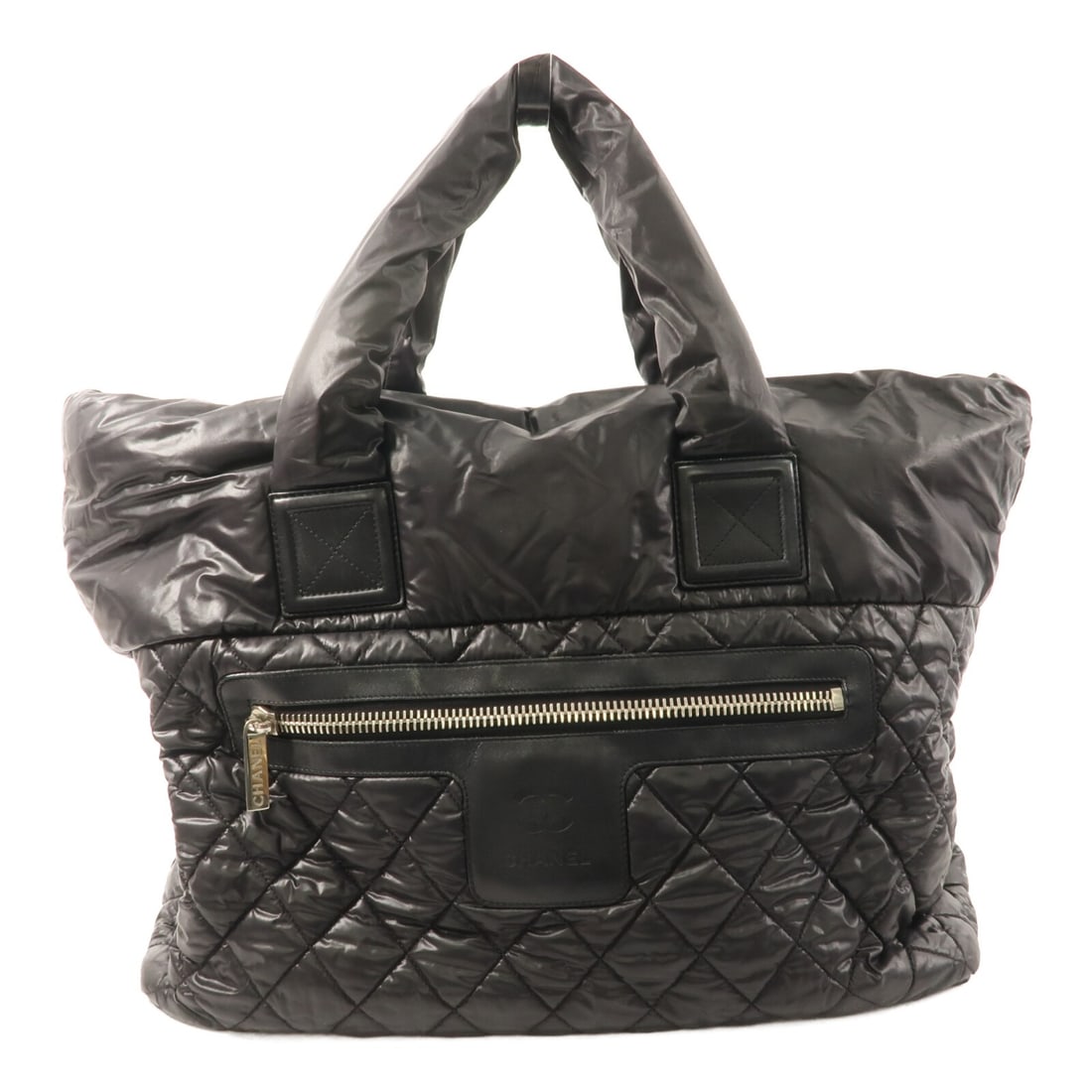 Black Nylon Chanel Coco Cocoon Tote Bag: Black Nylon Chanel Coco Cocoon Tote Bag This CHANEL Coco Cocoon tote bag is crafted from durable black nylon and features the iconic CC logo with silver-tone hardware. Designed for women, the spacious