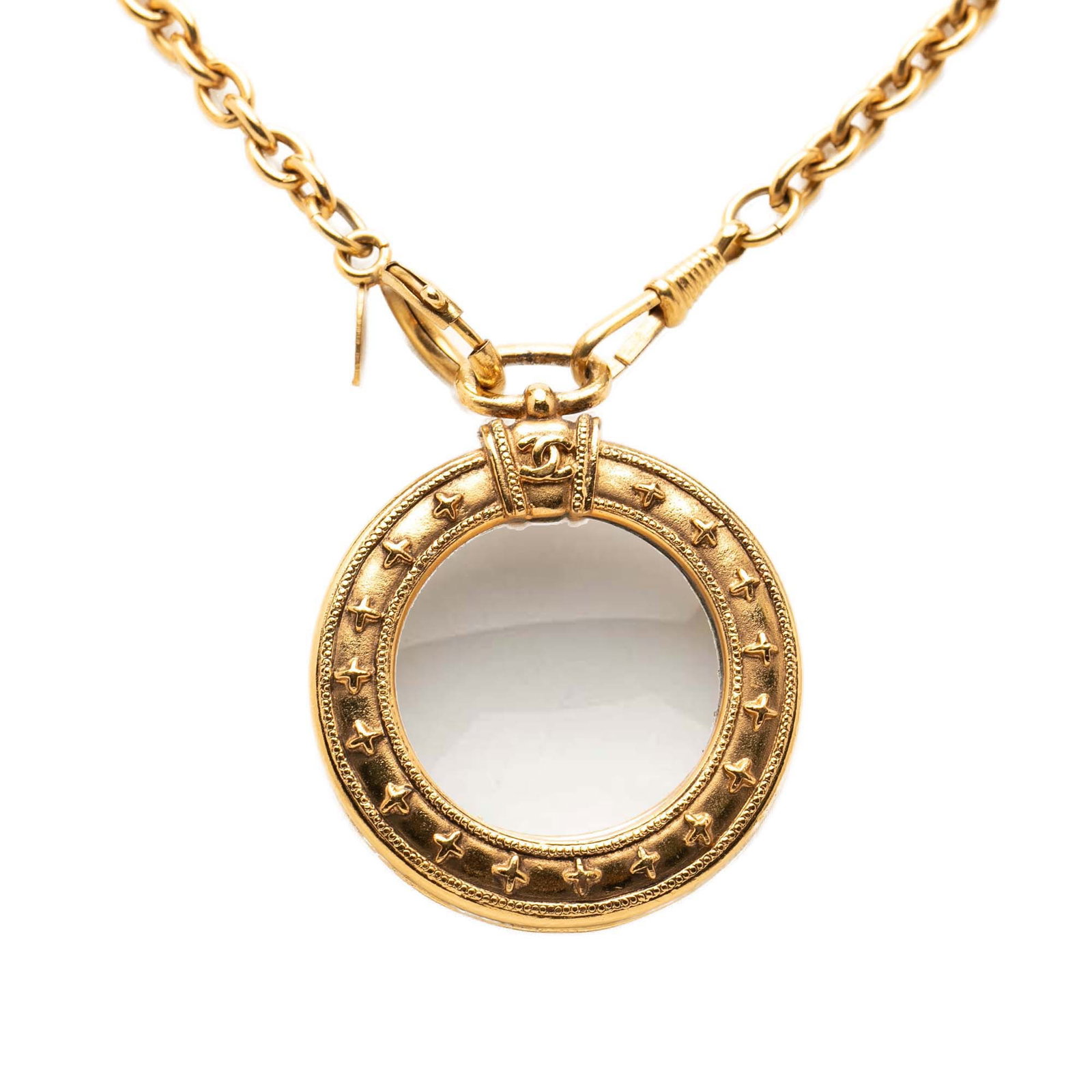 Chanel gold plated long necklace with magnifying glass pendant: Chanel gold plated long necklace with magnifying glass pendant This Chanel necklace features a gold plated metal body with a round magnifying glass pendant. The necklace is designed with a long chain 