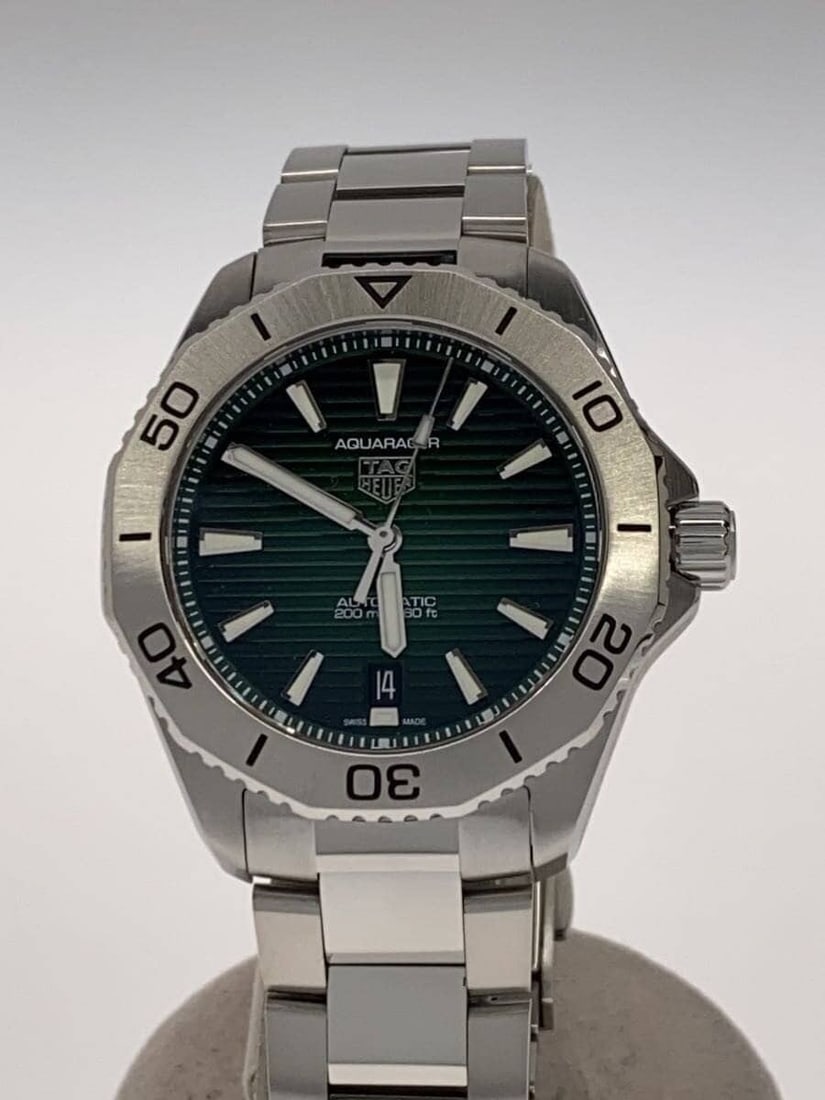 TAG Heuer Aquaracer Swiss Men's Wristwatch: TAG Heuer Aquaracer Swiss Men's Wristwatch This TAG Heuer Aquaracer men's wristwatch is a Swiss-made timepiece designed for durability and style. The watch shows slight signs of use and is in pre-owne