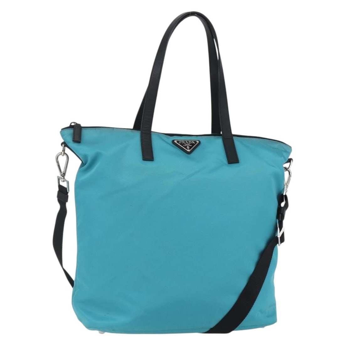 PRADA Turquoise Blue Nylon 2way Tote Bag Auth 7/T Italy: PRADA Turquoise Blue Nylon 2way Tote Bag Auth 7/T Italy Introducing a stylish PRADA Tote Bag crafted from durable nylon in a vibrant turquoise blue and silver color scheme. This versatile bag features