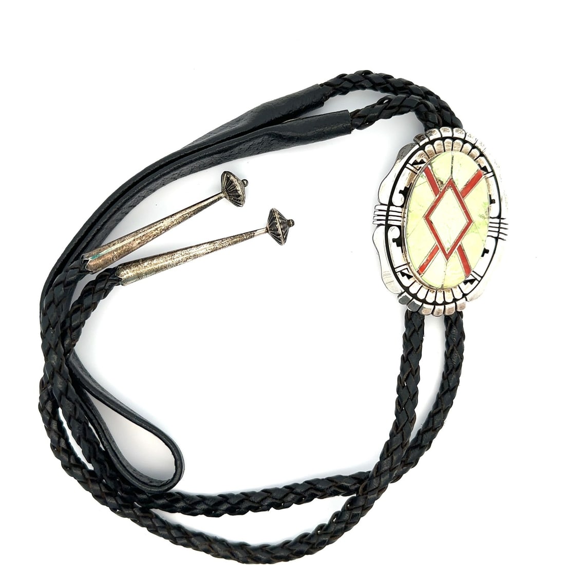 Sterling Silver Bolo Tie with Gaspeite and Coral Inlay by Gilbert Nelson: Sterling Silver Bolo Tie with Gaspeite and Coral Inlay by Gilbert Nelson This vintage bolo tie features a custom-crafted design by Gilbert Nelson, showcasing inlay-set natural gaspeite stones in a min