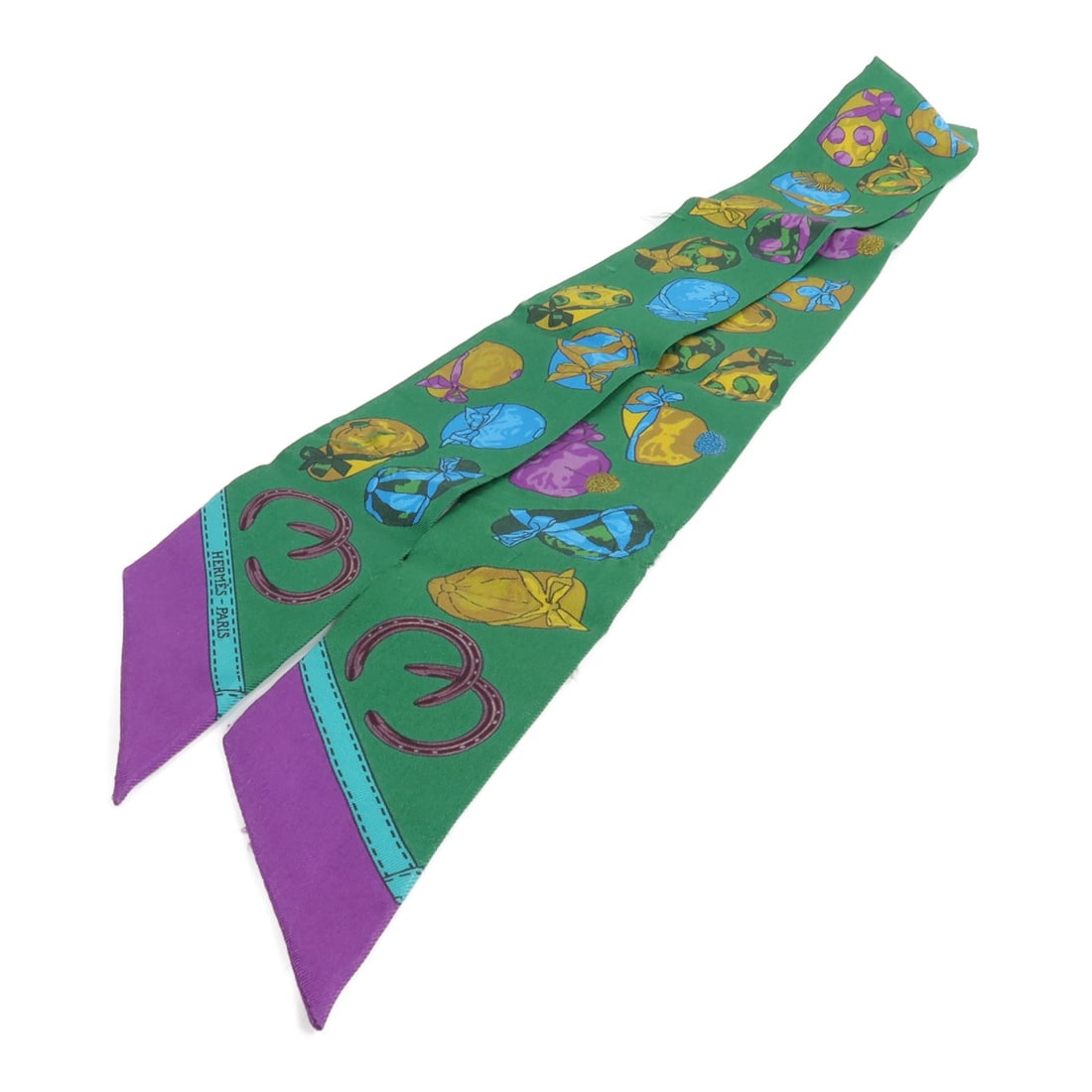Hermes Silk Twilly in Green and Purple: Hermes Silk Twilly in Green and Purple This Hermes Twilly scarf is crafted from luxurious silk and features a striking green and purple color palette. Designed for women, it showcases the renowned qua