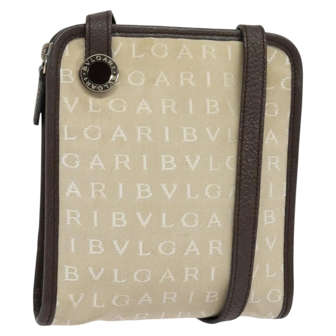Beige Canvas Logo Mania Shoulder Bag by BVLGARI Italy: Beige Canvas Logo Mania Shoulder Bag by BVLGARI Italy This BVLGARI Logo Mania shoulder bag features a beige canvas exterior and is designed for women. Made in Italy, the bag offers a compact size and 