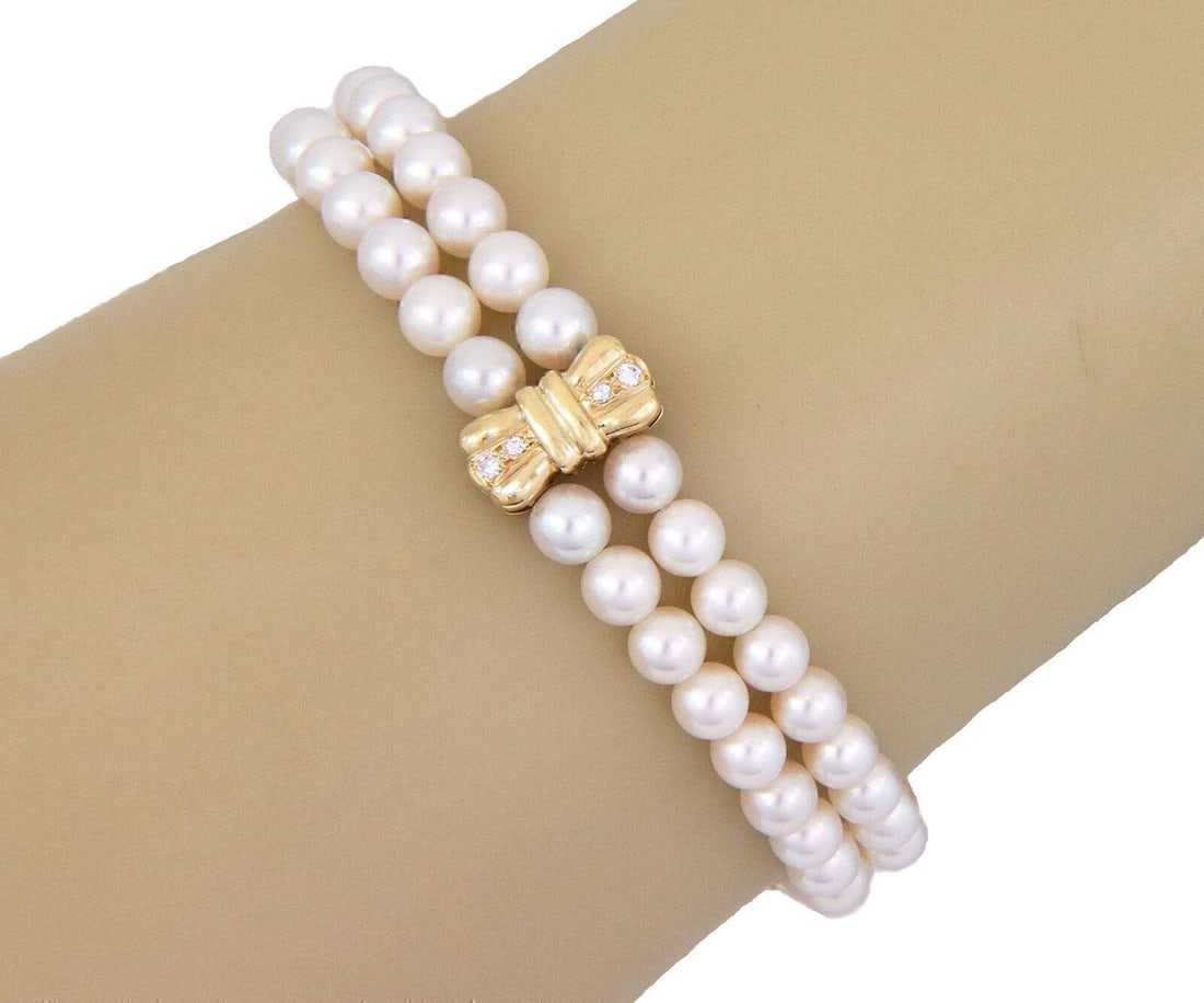 Mikimoto 18k Yellow Gold Pearl Diamond Bow Bracelet Two Strand: Mikimoto 18k Yellow Gold Pearl Diamond Bow Bracelet Two Strand This Mikimoto bracelet features two strands of luminous cultured pearls accented by a refined diamond-set bow motif, all crafted in 18k y