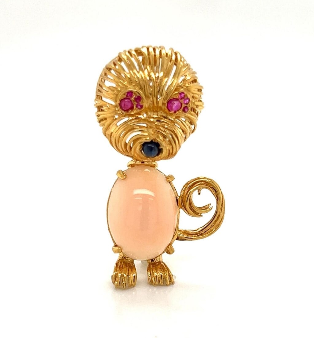 Vintage 18k Yellow Gold Cat Brooch with Coral Rubies Sapphires: Vintage 18k Yellow Gold Cat Brooch with Coral Rubies Sapphires This vintage cat motif brooch is crafted from 18k yellow gold and showcases a sculpted feline design. The piece features a vibrant red co