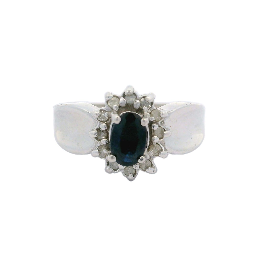 10k White Gold Oval Blue Sapphire Diamond Flower Halo Cocktail Ring: 10k White Gold Oval Blue Sapphire Diamond Flower Halo Cocktail Ring This stunning cocktail ring showcases an oval blue sapphire, elegantly surrounded by a flower halo of diamonds. Crafted from solid 1
