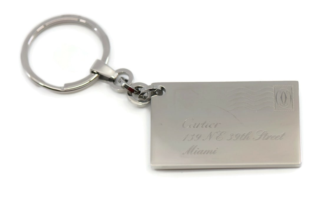 Stainless Steel Miami Key Chain by Cartier with Original Box: Stainless Steel Miami Key Chain by Cartier with Original Box This Cartier Miami key chain is crafted from stainless steel and features a sleek silver tone. Designed for men, it comes from Cartier and 