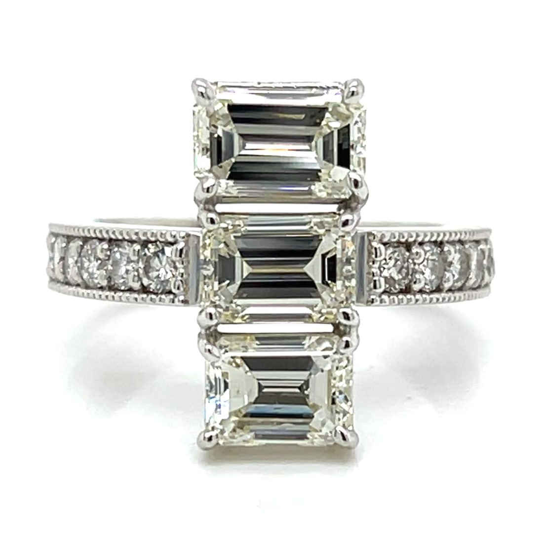 18K White Gold 3.90 Ct Diamond Ring with Emerald-Cut Center: 18K White Gold 3.90 Ct Diamond Ring with Emerald-Cut Center This stunning ring features a luxurious design crafted from 18K white gold and showcases a total diamond weight of 3.90 carats. The centerpi