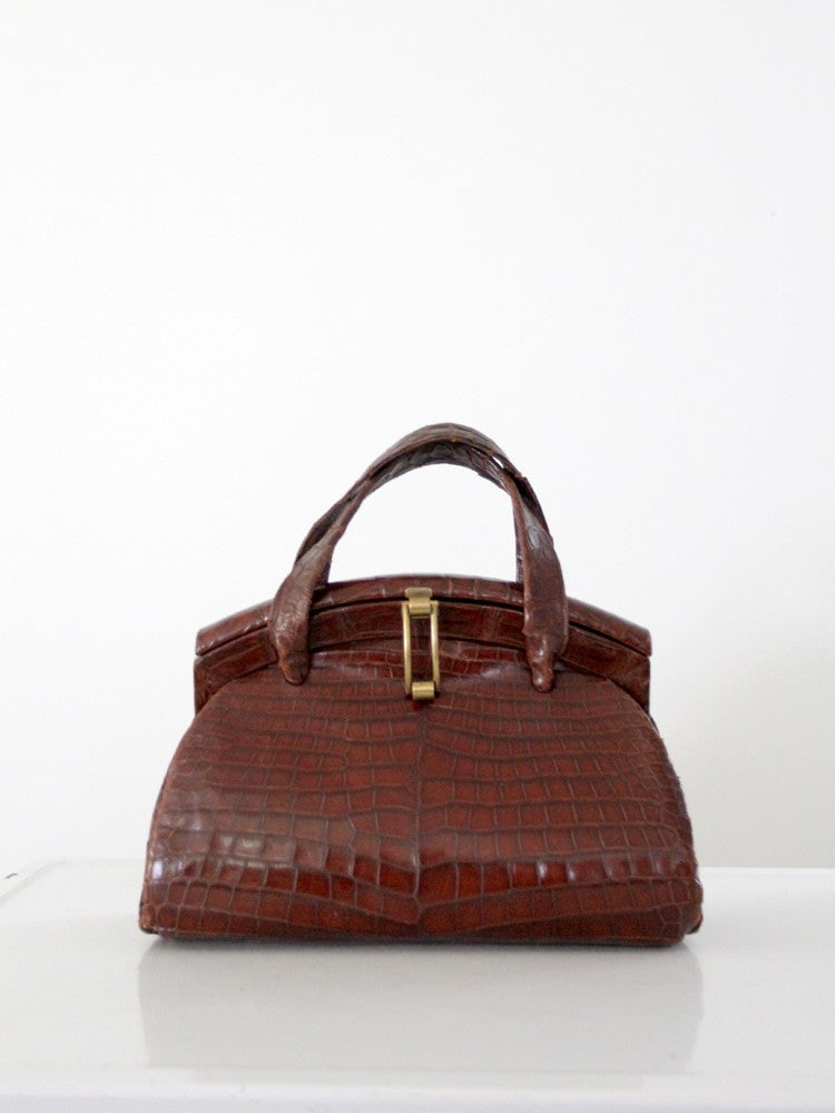 Vintage 1950s Alligator Skin Purse with Brass Fixtures: Vintage 1950s Alligator Skin Purse with Brass Fixtures This vintage alligator skin purse from the late 1950s is a stylish accessory that combines timeless elegance with practical design. It features a