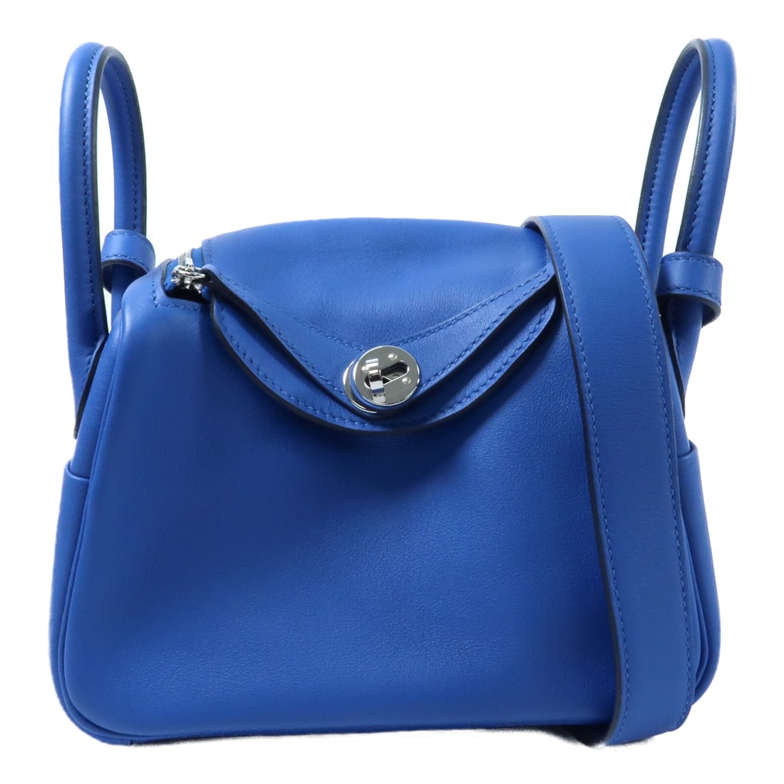 Hermes Mini Lindy Bleu Royal Calfskin 2 Way Shoulder Bag PHW: Hermes Mini Lindy Bleu Royal Calfskin 2 Way Shoulder Bag PHW This Hermes Mini Lindy 2-way shoulder bag is crafted from Vaux Swift calfskin leather in a striking Bleu Royal color. Made in France, the b
