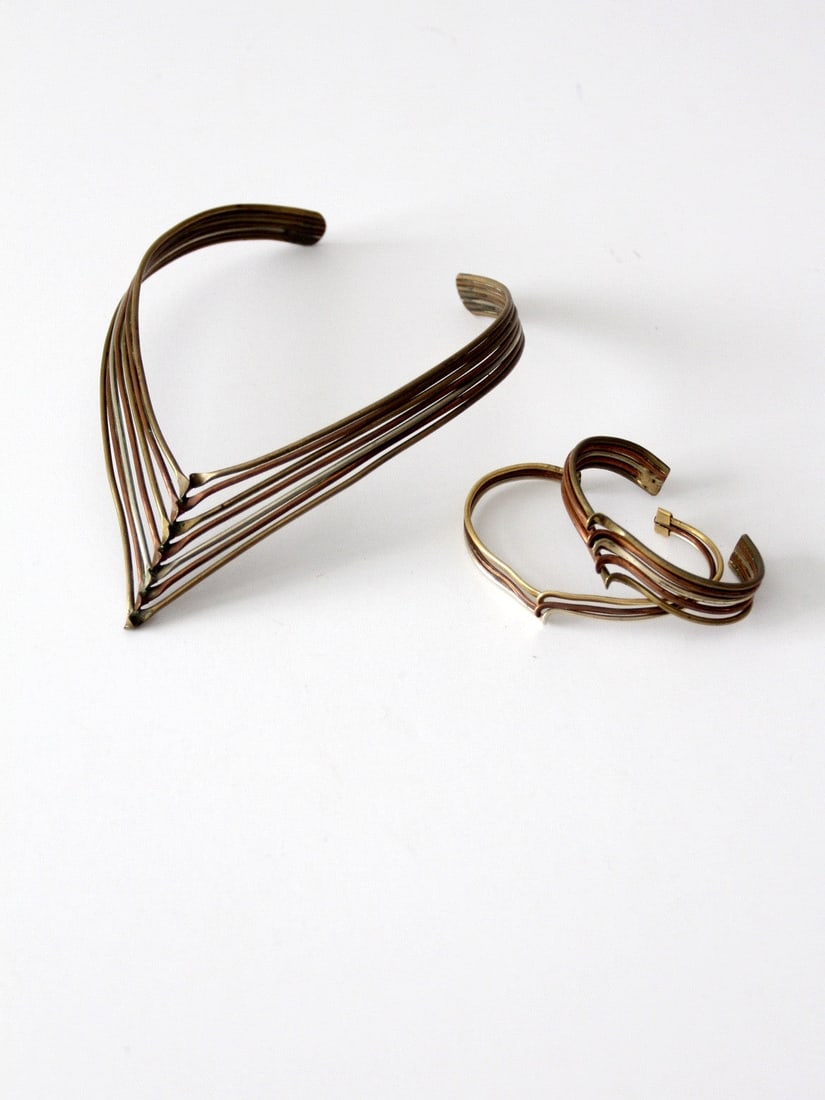 1970s Mixed Metal Choker and Cuff Bracelet Set: 1970s Mixed Metal Choker and Cuff Bracelet Set This vintage 1970s jewelry set includes a choker necklace and two cuff bracelets crafted from a mix of brass, copper, and silver tone metals. Each piece 