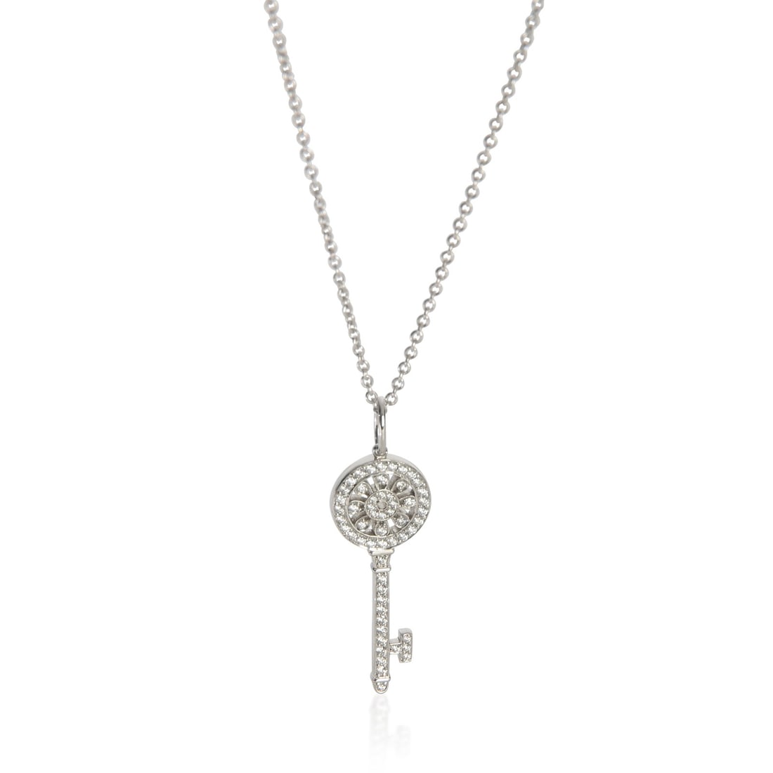 Tiffany & Co. Platinum Diamond Petals Key Pendant with Pouch: Tiffany & Co. Platinum Diamond Petals Key Pendant with Pouch This Tiffany & Co. Mini Model Petals Key pendant is crafted from platinum with a round brilliant diamond design. The pendant features a tot