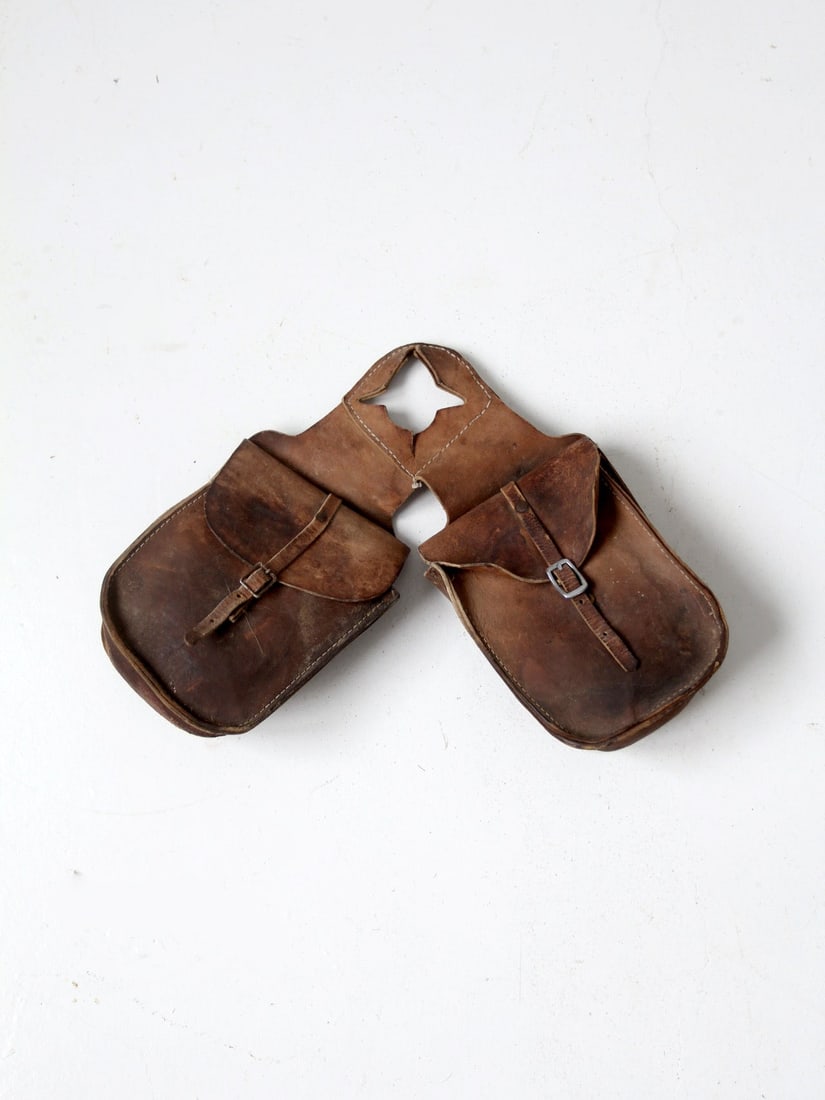 Vintage Hand-Crafted Leather Saddle Bags with Cream Stitching: Vintage Hand-Crafted Leather Saddle Bags with Cream Stitching Discover a pair of vintage hand-crafted leather saddle bags, designed to attach to a horse saddle's horn. These bags, made from thick brow