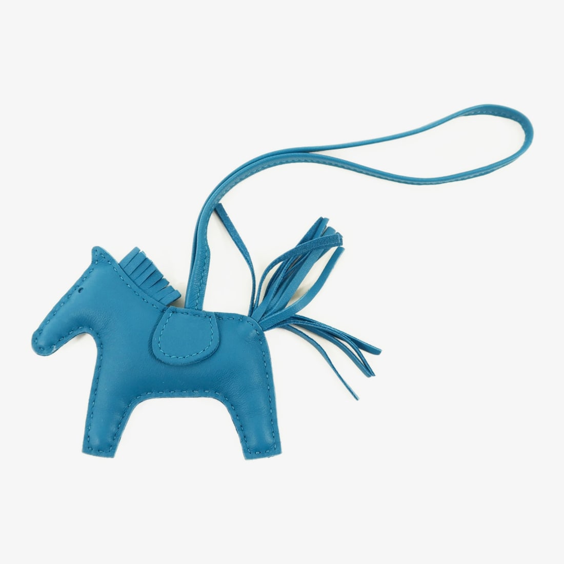 Hermes Rodeo PM Blue Lambskin Bag Charm for Women: Hermes Rodeo PM Blue Lambskin Bag Charm for Women The Hermes Rodeo PM Charm is crafted from Milo lambskin leather in a striking blue color. Designed for women, this elegant charm adds a playful and lu