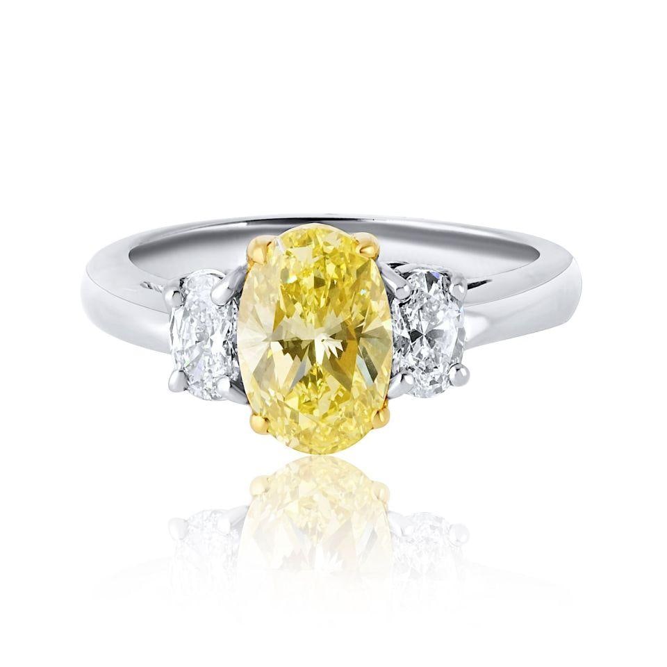 1.54 Carat Oval Fancy Intense Yellow Diamond Three Stone Ring: 1.54 Carat Oval Fancy Intense Yellow Diamond Three Stone Ring This exquisite three-stone engagement ring showcases a vibrant 1.54-carat oval cut diamond with a stunning Fancy Intense Yellow hue, GIA c