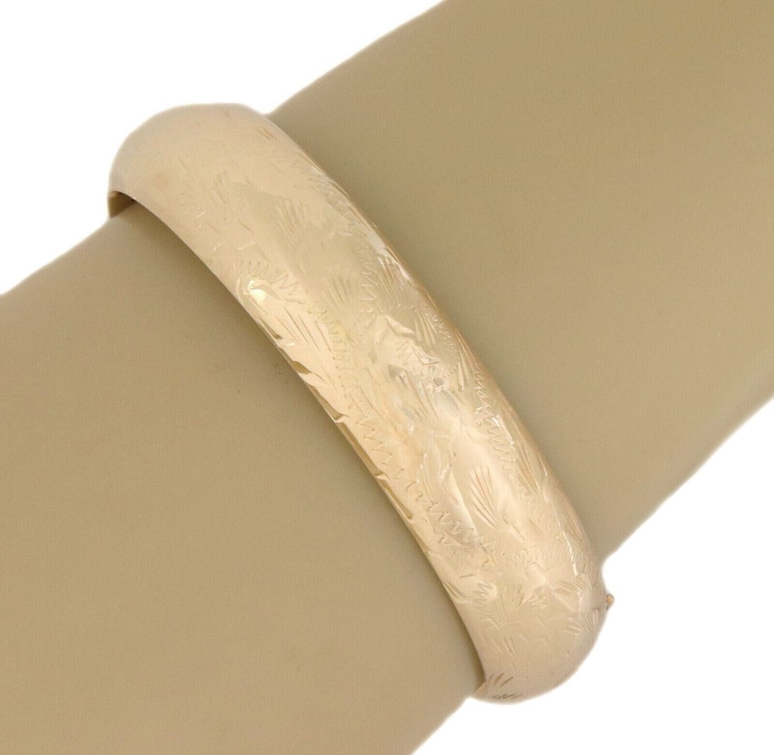 14K Yellow Gold Hinged Wide Dome Bangle Bracelet: 14K Yellow Gold Hinged Wide Dome Bangle Bracelet This vintage wide dome bangle bracelet is crafted from solid 14k yellow gold and features a polished finish. The bracelet showcases a sculptural design