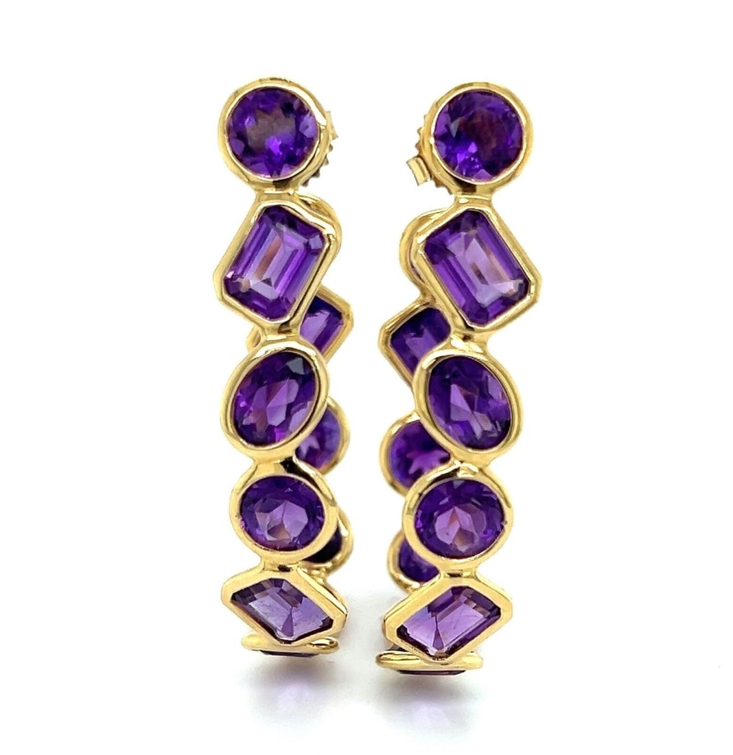 Vintage 18k Yellow Gold Amethyst Hoop Earrings: Vintage 18k Yellow Gold Amethyst Hoop Earrings These vintage hoop earrings feature elegant inside-out designs crafted in solid 18k yellow gold. Each earring is adorned with richly colored oval amethys