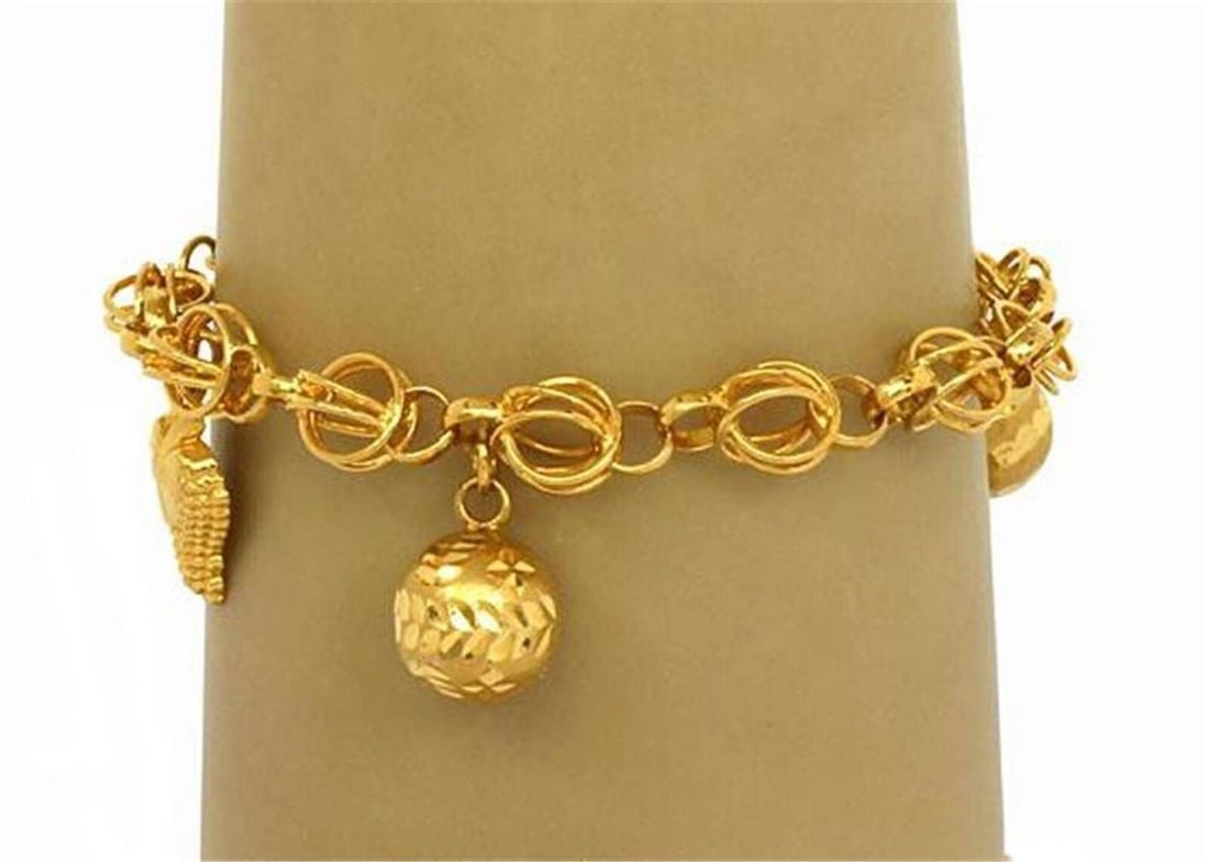Vintage 21k Yellow Gold Charm Link Bracelet: Vintage 21k Yellow Gold Charm Link Bracelet This vintage charm link bracelet is expertly handcrafted in 21k yellow gold, showcasing bold sculptural links adorned with four detailed dangling charms. Th