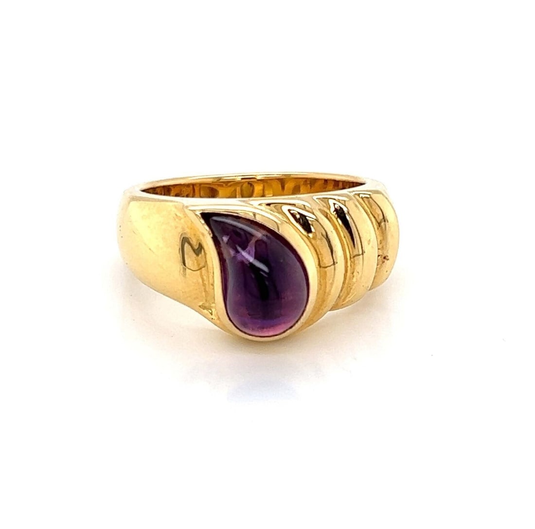 Chopard 18k Yellow Gold Amethyst Ring Size 6 Ribbed Bezel: Chopard 18k Yellow Gold Amethyst Ring Size 6 Ribbed Bezel This authentic Chopard ring is expertly crafted in 18k yellow gold and features a teardrop-shaped cabochon amethyst set in a polished bezel. T