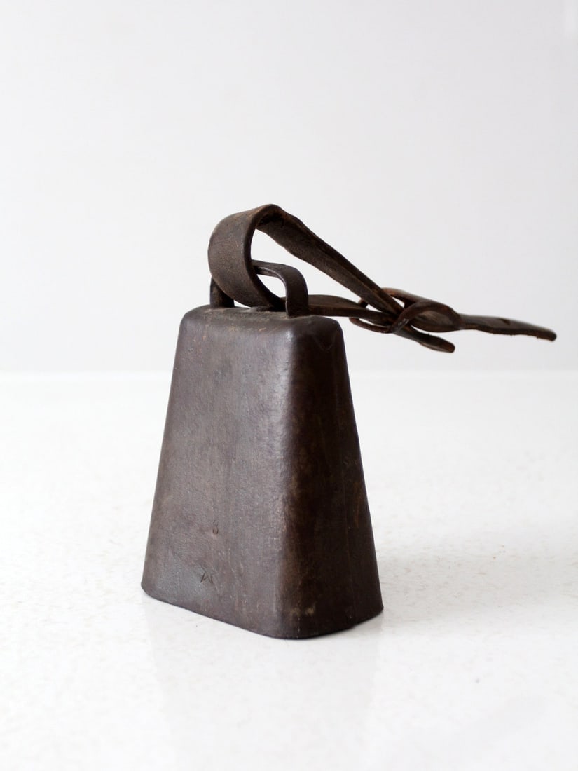 Vintage Antique Cow Bell with Leather Strap Rustic Decor: Vintage Antique Cow Bell with Leather Strap Rustic Decor This antique cow bell showcases a distinctive leather buckled strap and a beautifully weathered patina, enhancing its rustic charm. Ideal for d