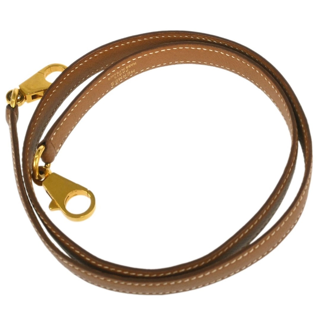 Hermes Kelly bag shoulder strap gold Courchevel leather: Hermes Kelly bag shoulder strap gold Courchevel leather Hermes shoulder strap for the Kelly, crafted in Courchevel leather in a gold color. This women's accessory is made in France and presents in ver