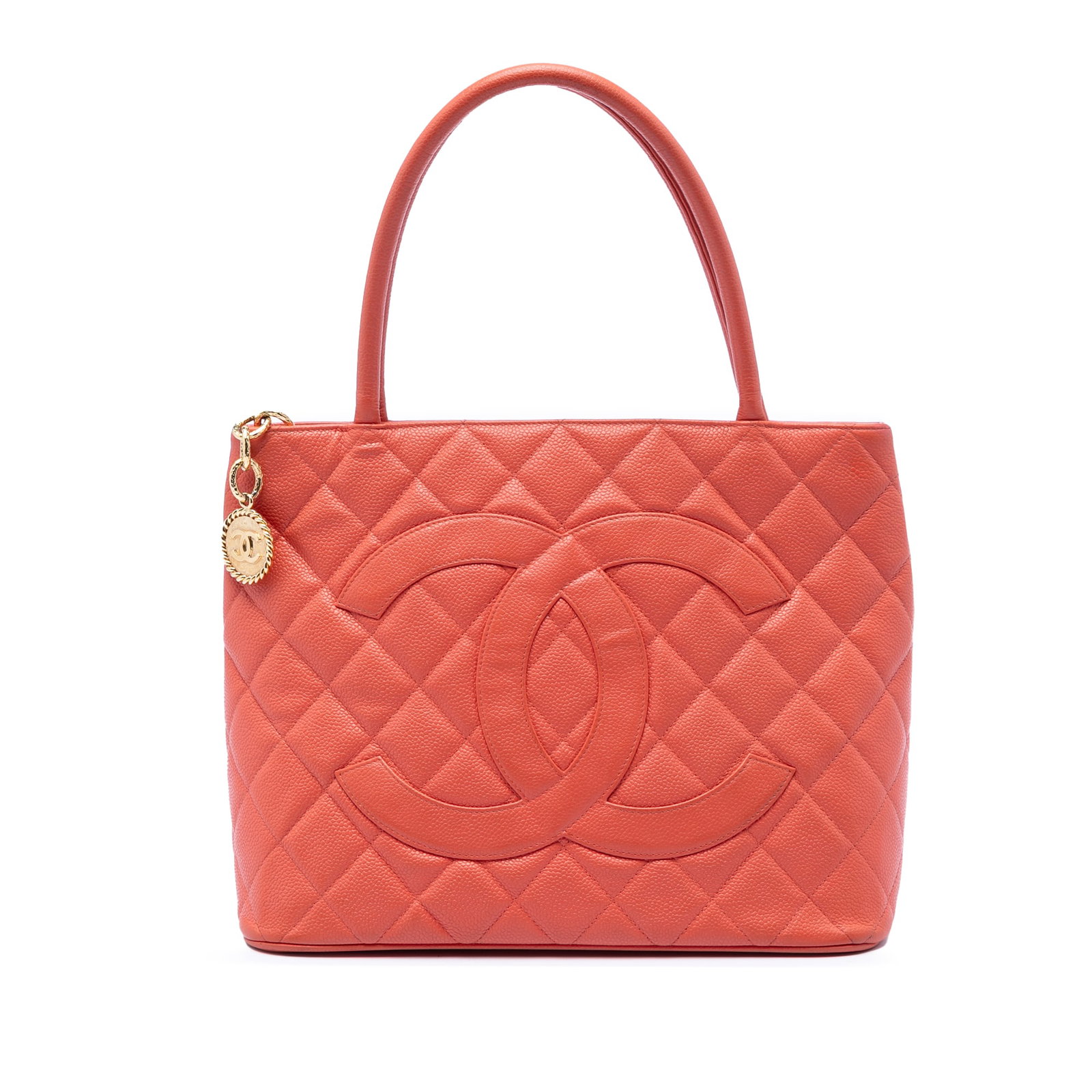 Chanel orange caviar leather medallion tote bag: Chanel orange caviar leather medallion tote bag This Chanel Caviar Medallion Tote features a quilted caviar leather body in orange, complemented by rolled handles and a top zip closure. The bag includ