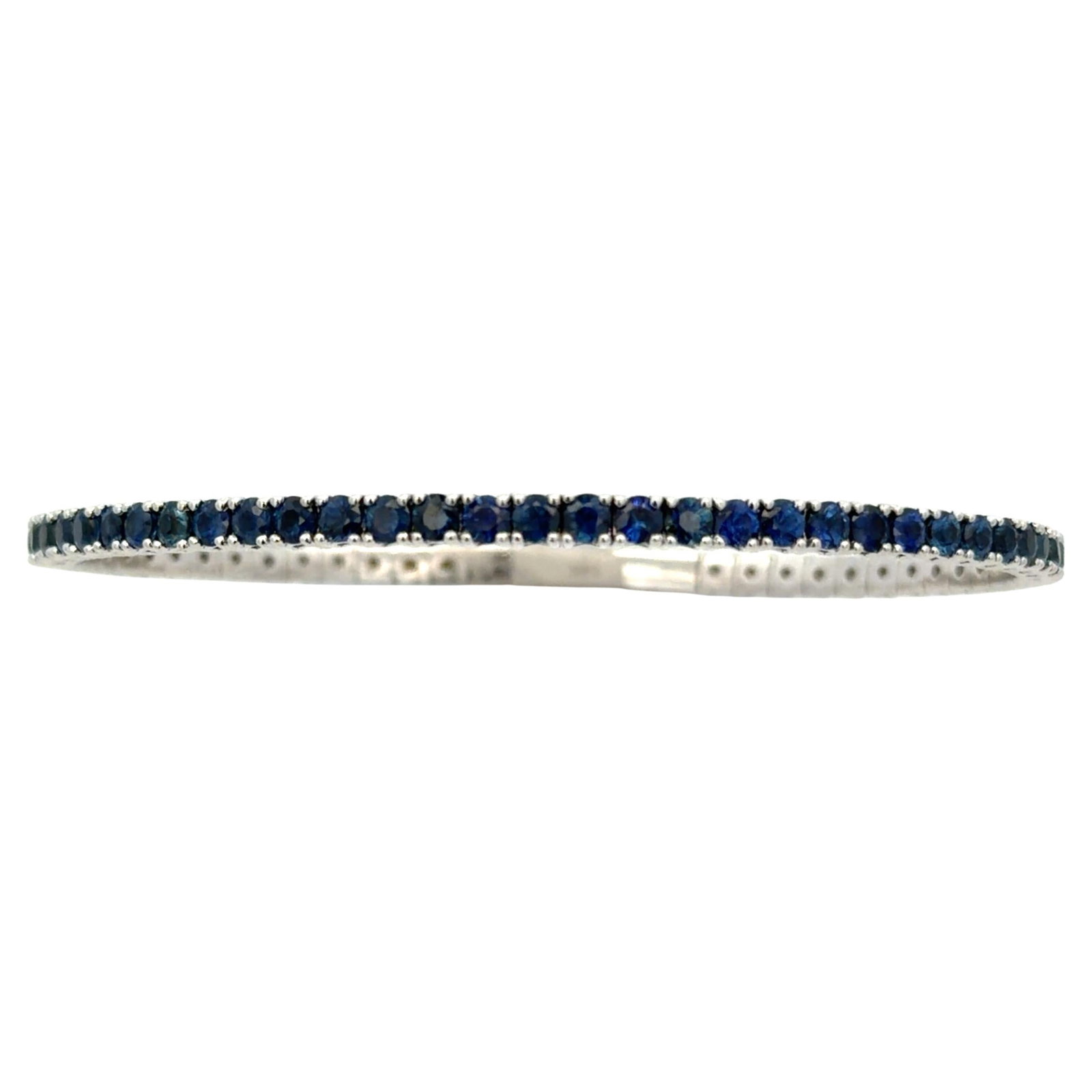 Flexible Sapphire Tennis Bangle in 14K White Gold 5.54 Carat: Flexible Sapphire Tennis Bangle in 14K White Gold 5.54 Carat This flexible tennis bangle bracelet showcases 59 vibrant round blue sapphires with a total weight of approximately 5.54 carats, each set i