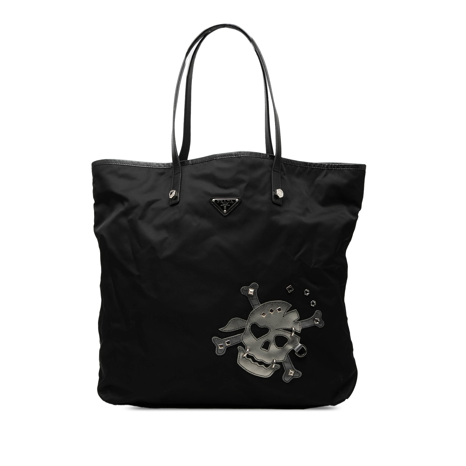 Prada black nylon skull patch tote bag: Prada black nylon skull patch tote bag This Prada Tessuto Skull Tote features a black nylon body with a distinctive skull patch, complemented by flat leather straps. The open top design allows easy ac