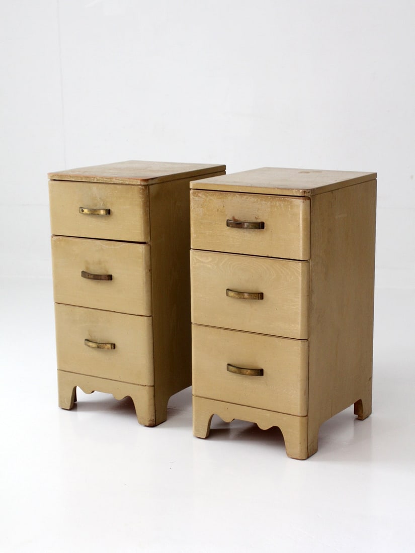 Pair of 1950s Transitional 3 Drawer Nightstands Brass Tone Hardware: Pair of 1950s Transitional 3 Drawer Nightstands Brass Tone Hardware This pair of vintage nightstands dates from the late 1940s to 1950s and features softly rounded edges, a warm parchment-toned finish